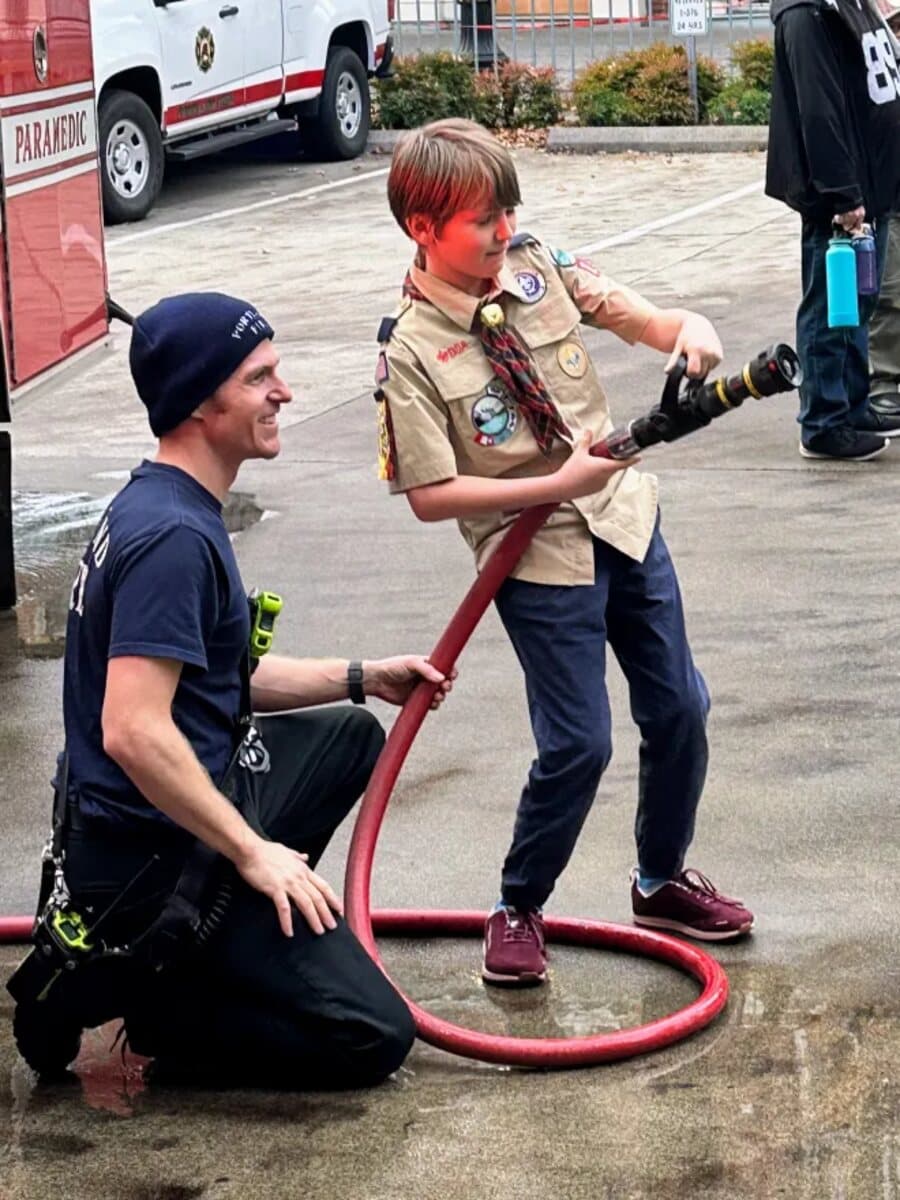 Asher as a Cub Scout on the hose at a Portland fire station